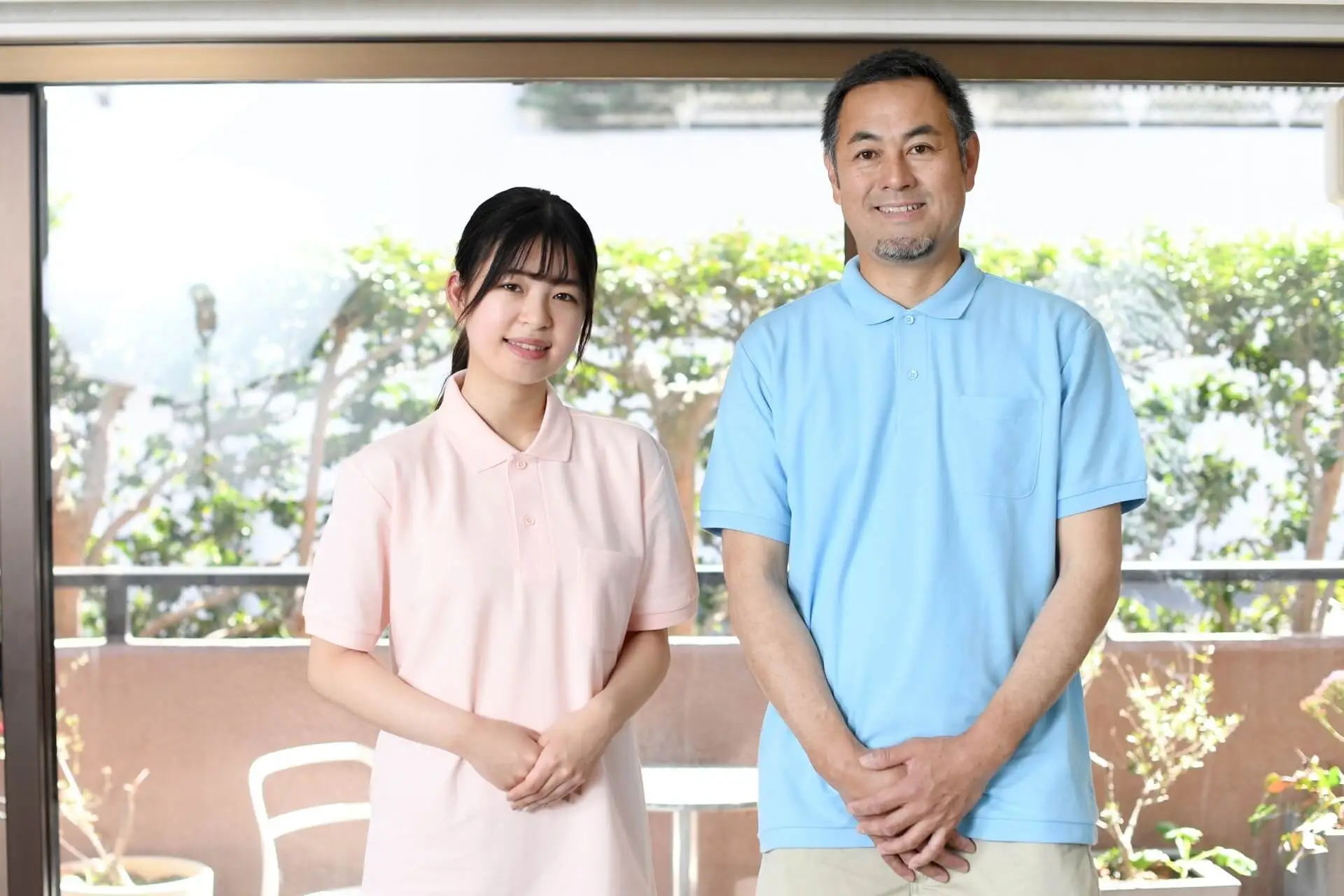 女性と男性の介護スタッフが、並んで笑顔でこちらを見つめている写真