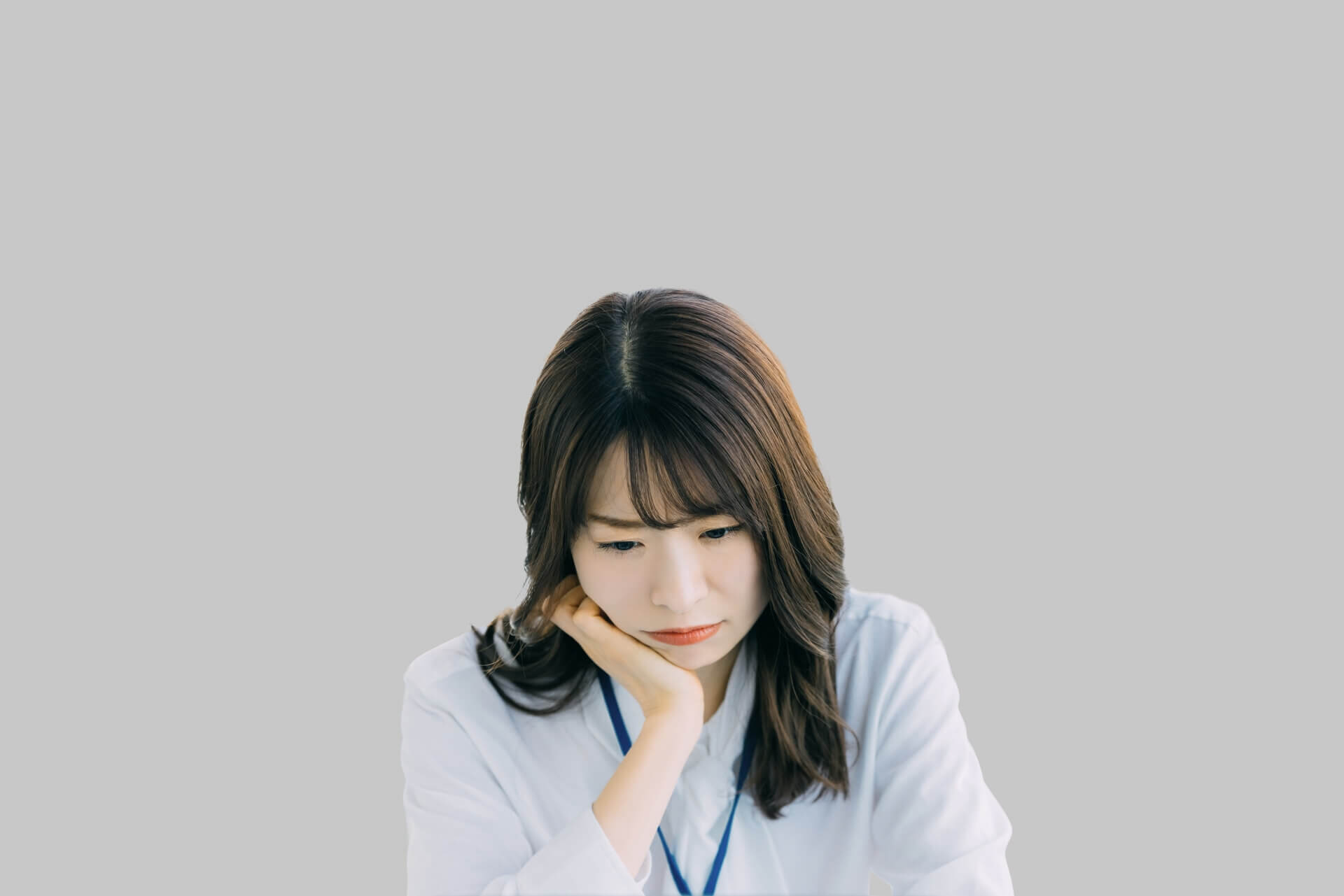 頬杖をついて考える女性の写真
