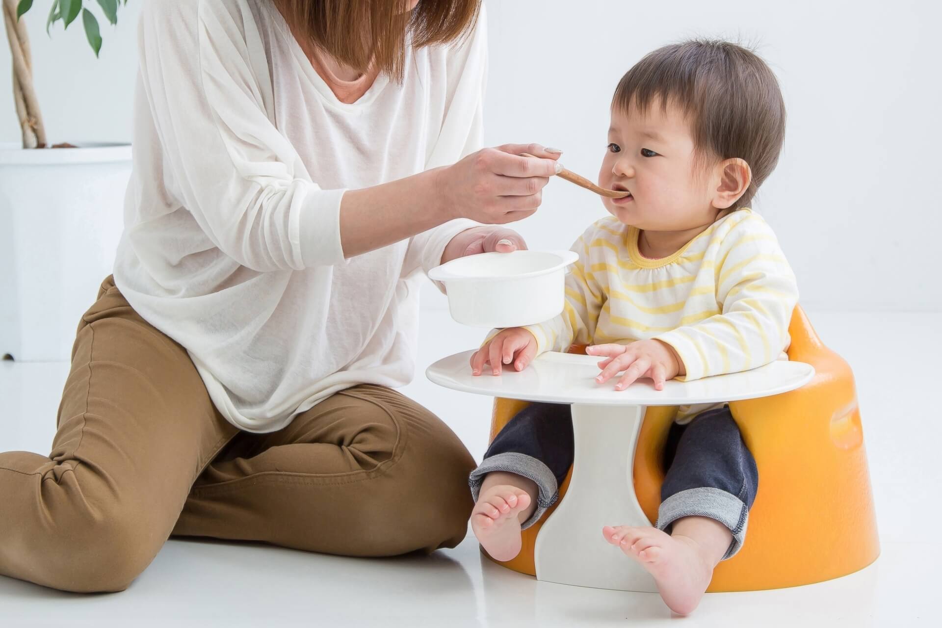乳幼児に食事を与える母親の写真