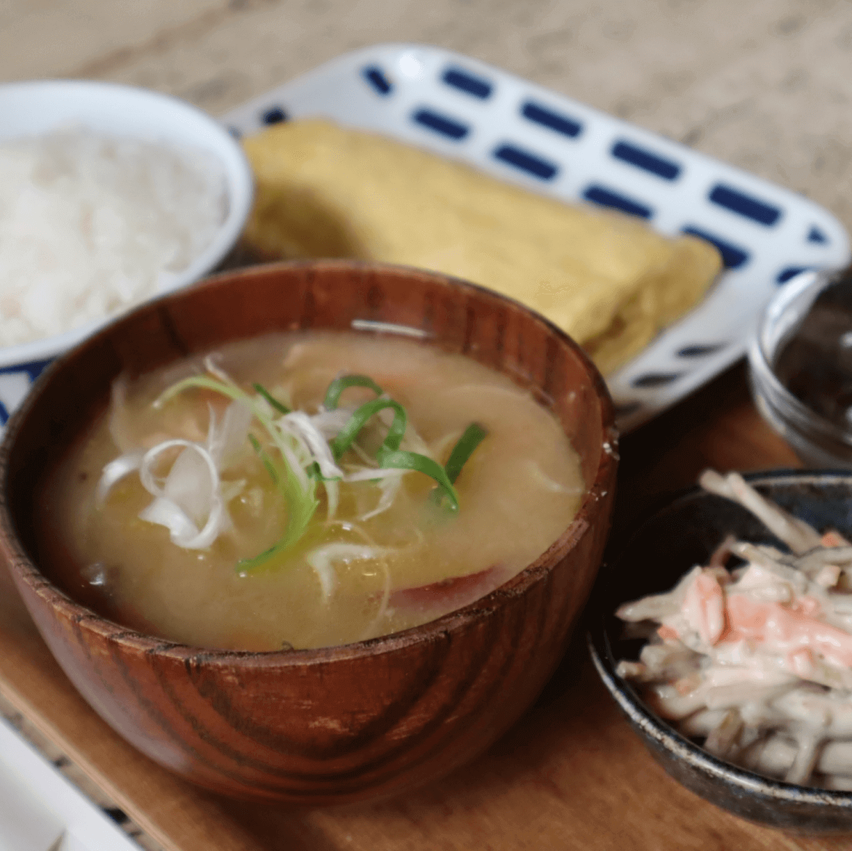 白米や味噌汁、卵焼きなどがある、和風な朝食の写真
