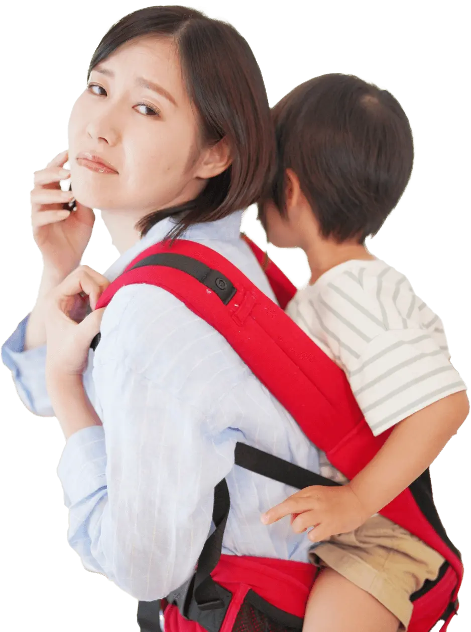 幼い男の子を背負っている、育児中の母親の写真