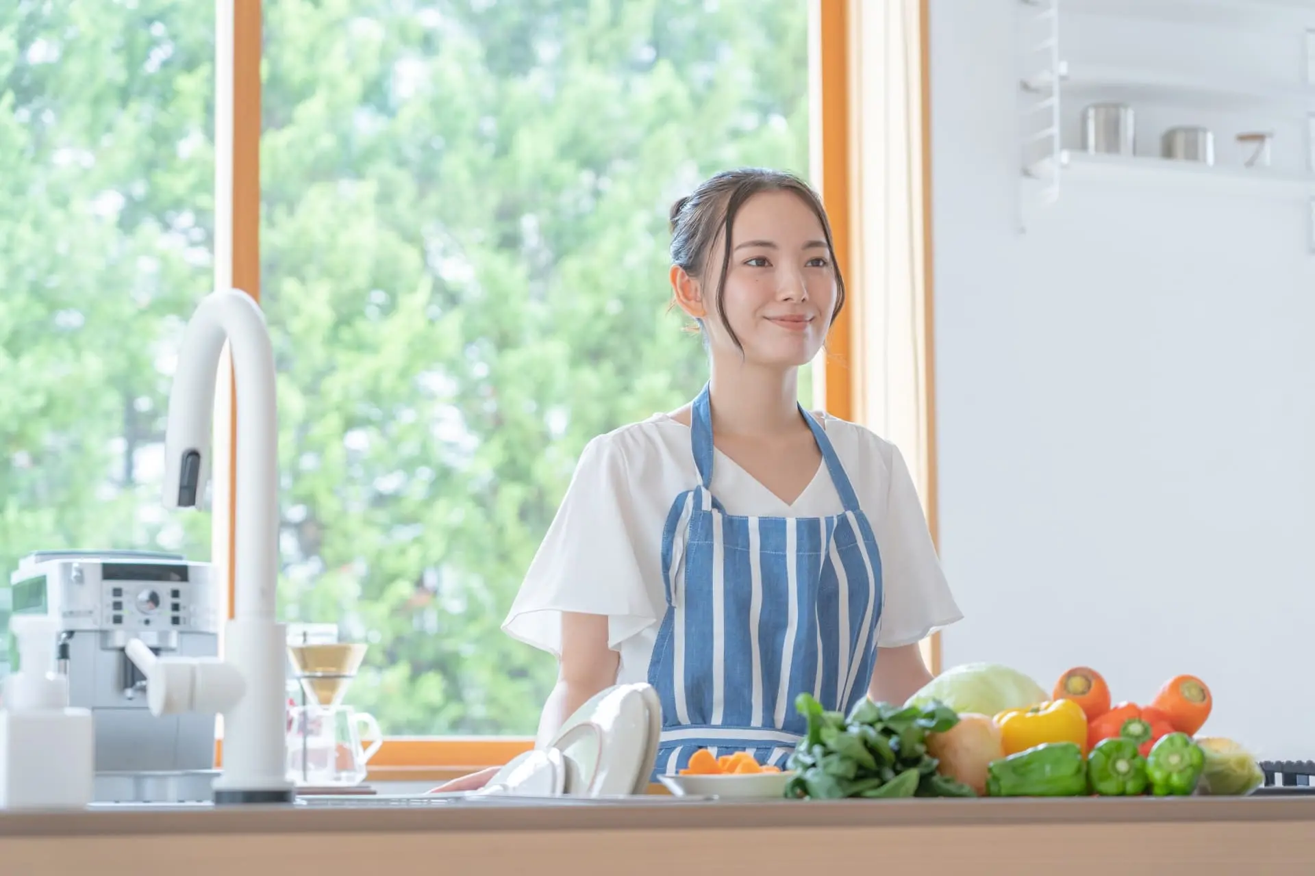 女性家事代行スタッフが綺麗なキッチンで料理をしている写真
