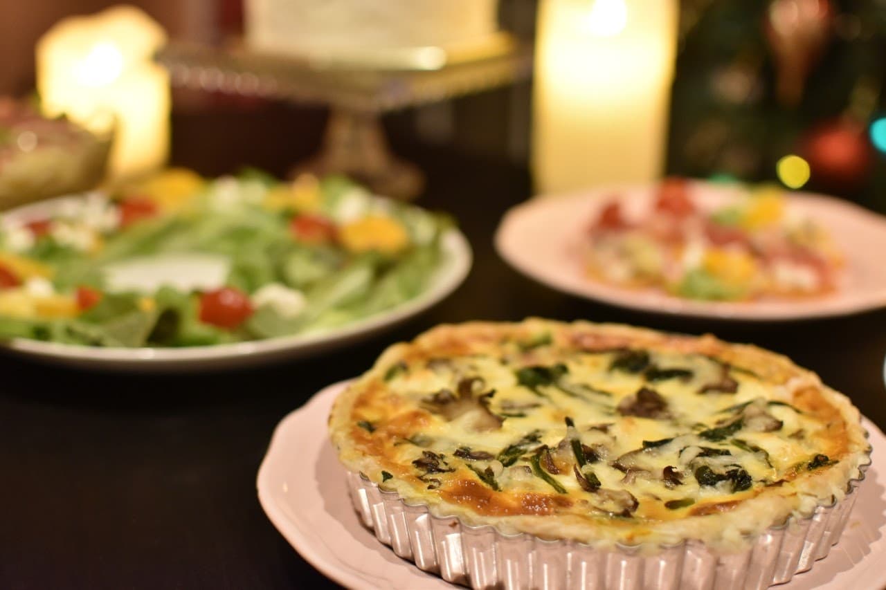 キッシュなどの美味しそうな料理が、複数食卓に並んでいる写真