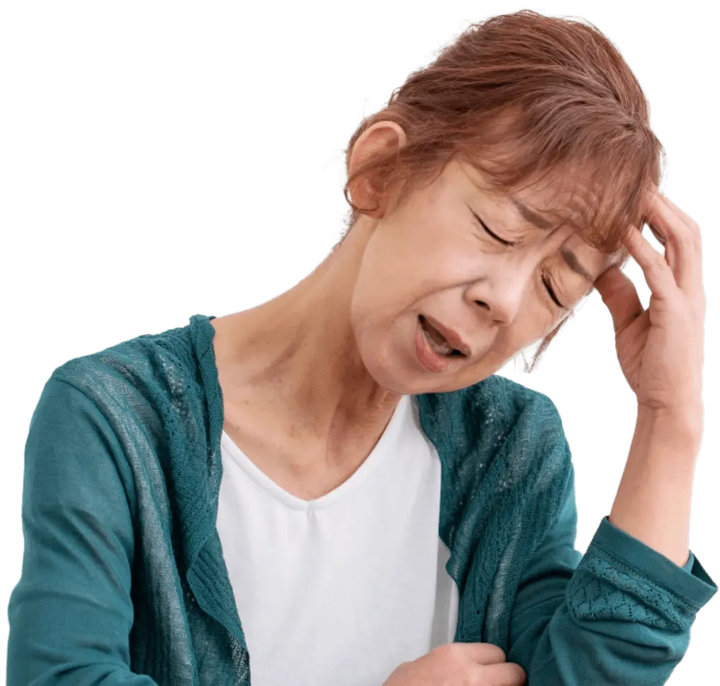 非常に困惑した表情で頭を抱えている熟年女性の写真
