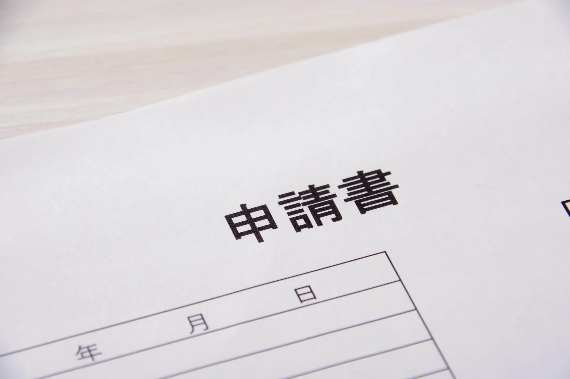 「申請書」と書かれた書類が机の上に置かれている写真